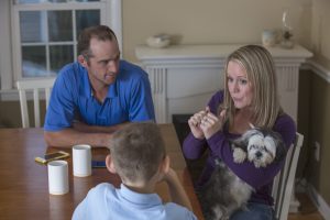 Caucasian family signing at dinner table Caucasian family signing at dinner table