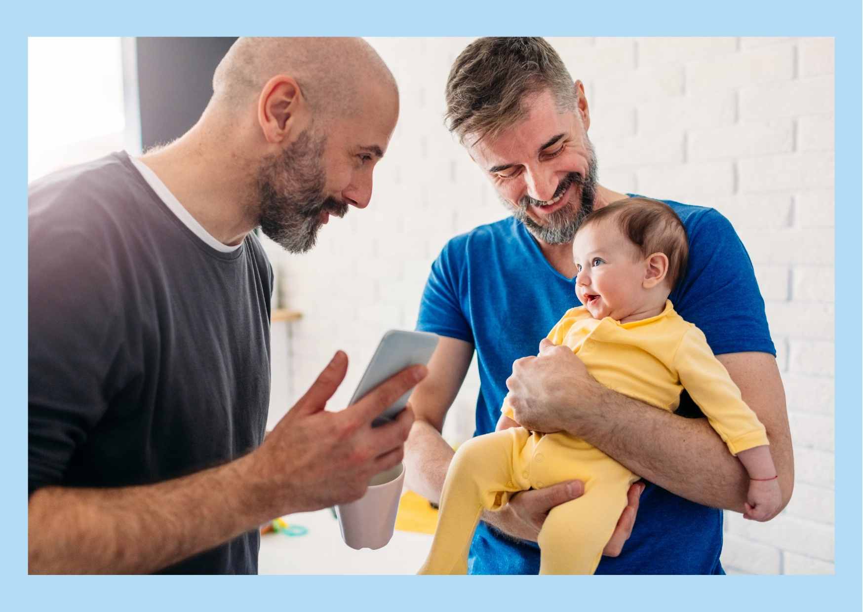 Two smiling men with a smiling baby.