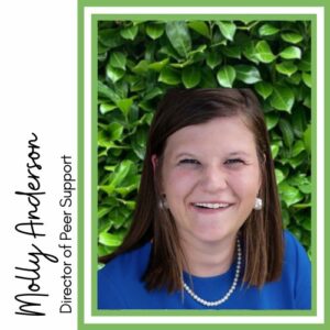 Headshot of Molly Anderson, Director of Peer Support. Molly is white woman with shoulder length brown hair. She is wearing a blue shirt. The background is green leaves.